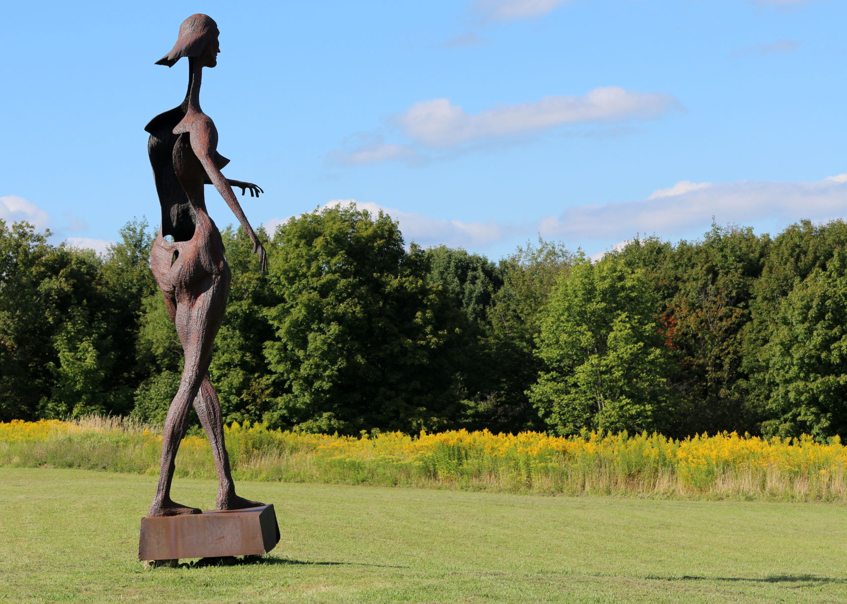 Tall steel sculpture of a woman witnesses seasons about to change